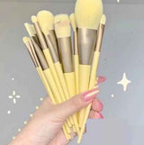 13-Piece Makeup Brush Set with soft yellow bristles and matching handles held in hand