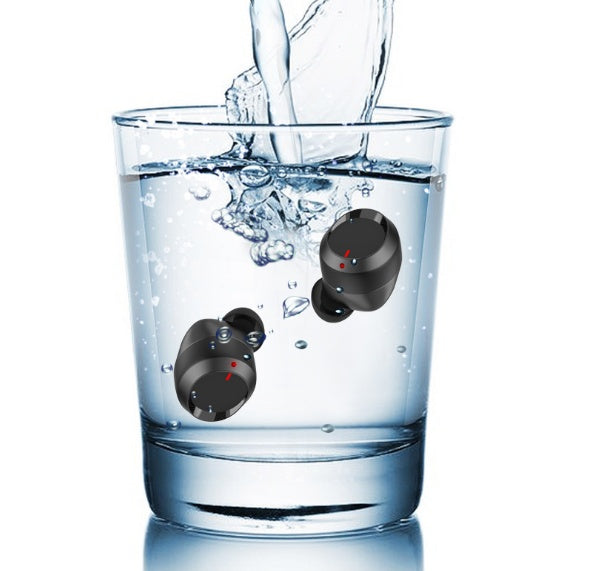 Black Bluetooth earbuds with charging case submerged in water showing waterproof feature