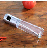 Petra store clear cooking oil spray bottle with stainless steel top on wooden surface