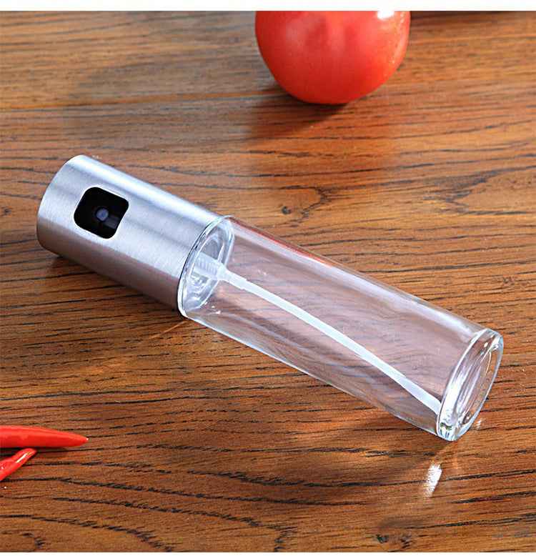 Petra store clear cooking oil spray bottle with stainless steel top on wooden surface