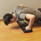 Man performing push-up using Petra store Push-up Board Bracket with color-coded hand positions on wooden floor