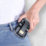 Hand holding a compact portable phone stand for desk being placed into a jeans pocket