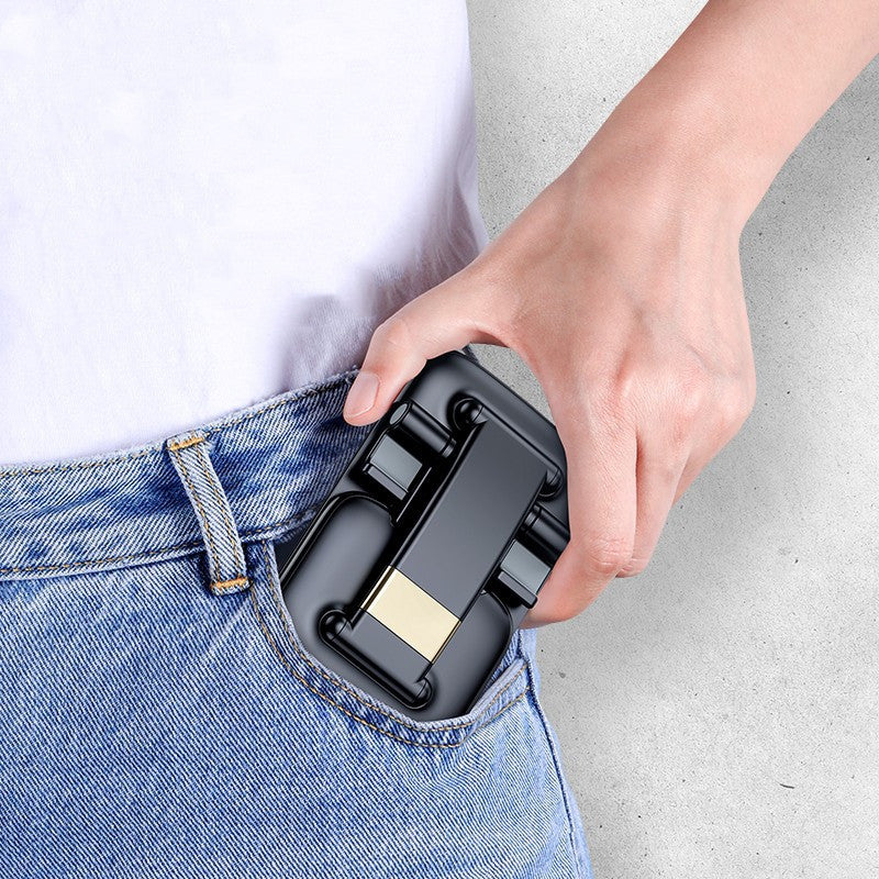 Hand holding a compact portable phone stand for desk being placed into a jeans pocket