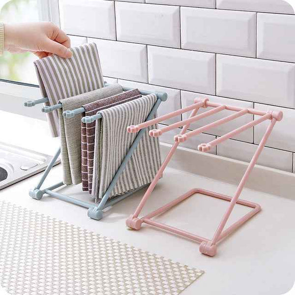 Petra store Foldable Dishcloth Shelf in pink and blue holding striped dishcloths on kitchen counter