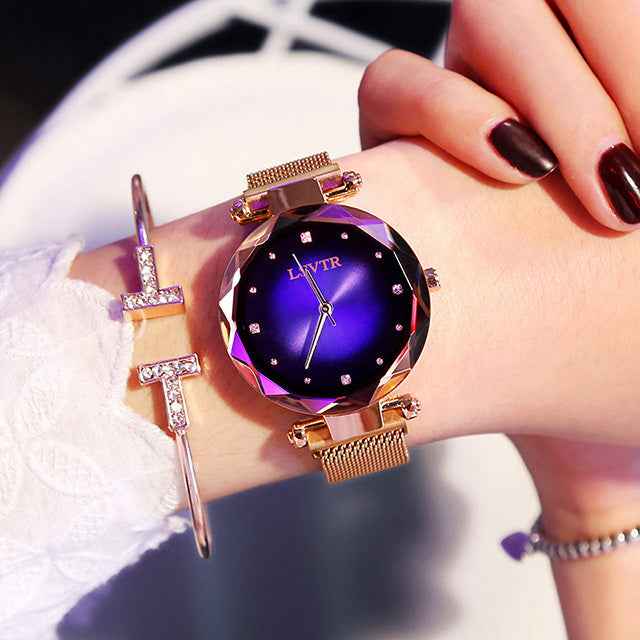 Petra store Rose Gold Watch with faceted purple sunburst dial mesh band and crystal hour markers on wrist