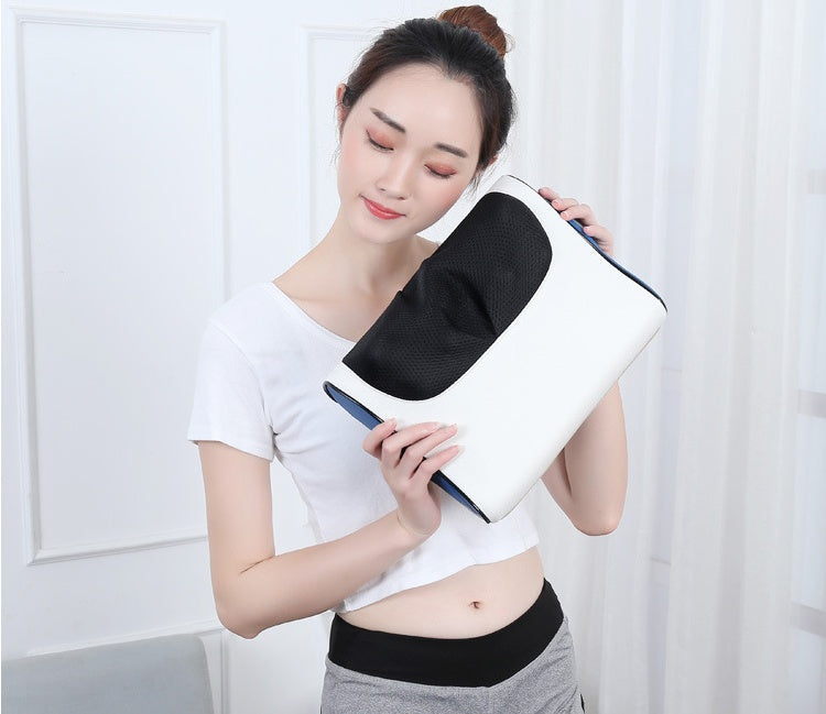 Petra store massage pillow in white and black held by woman in white crop top and gray pants