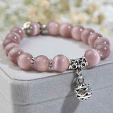Petra store natural opal beads bracelet with pink beads and silver charm on gray display