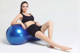 Woman in black workout outfit using a blue Peanut Massage Ball for muscle relaxation