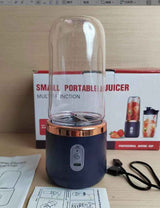 Petra store Portable Blender And Mini Juicer with clear container and USB charging cable on wooden surface