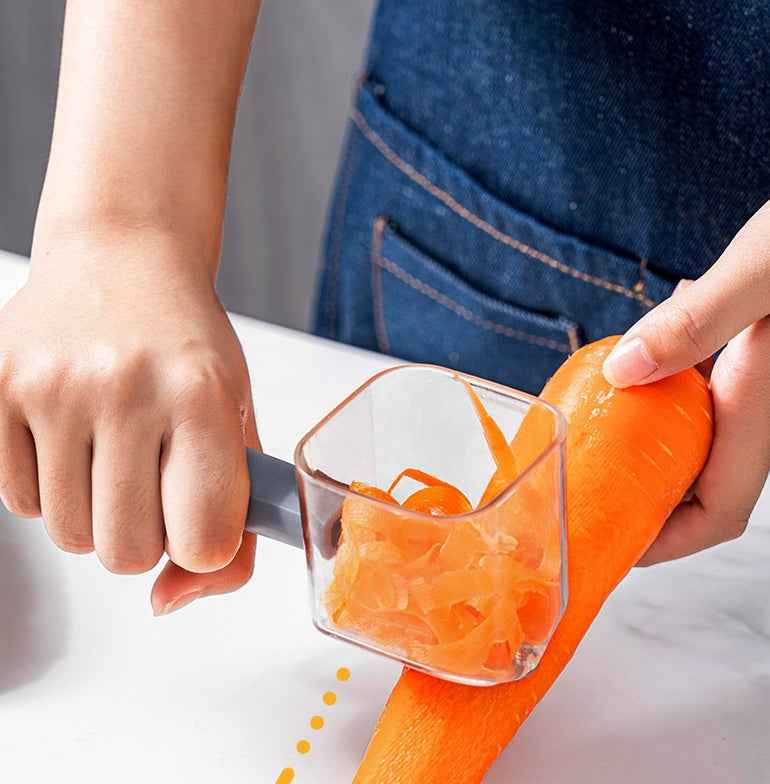 Stainless Steel Single Head Peeler peeling a fresh carrot on a white countertop in kitchen