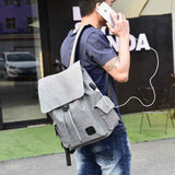 Gray travel backpack for teenage girls worn by a person outdoors near a storefront