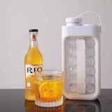 Petra store portable ice ball maker kettle with clear mold next to whiskey glass and bottle