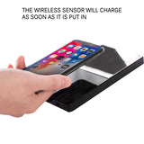 Petra store USB mug warmer with phone charging black glossy pad showing hand placing smartphone for wireless charging