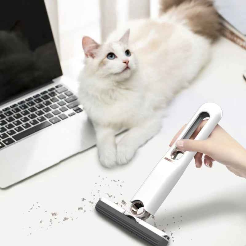Petra store Mini Cleaning Mop in white being used to clean debris near a laptop and a white cat
