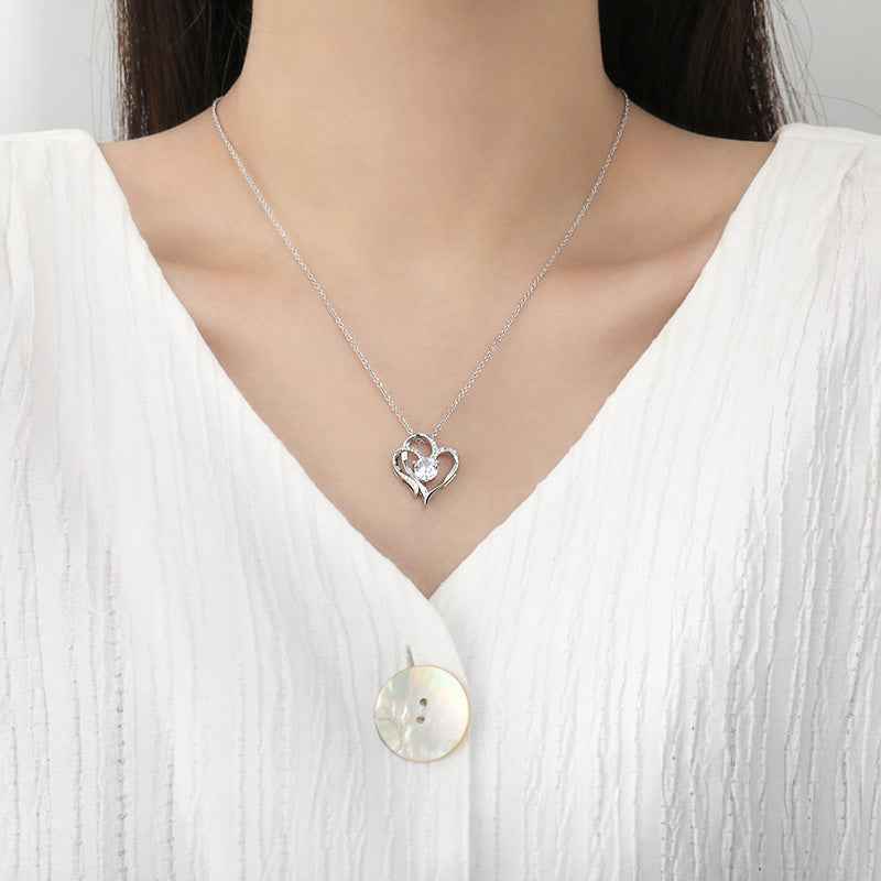 Zircon Double Love Necklace with heart-shaped pendant on silver chain worn with white top